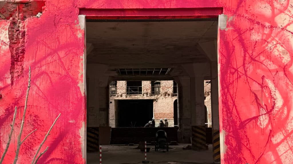 Acceso enmarcado por paramentos rojos con perspectiva hacia el interior del Palacio Molina