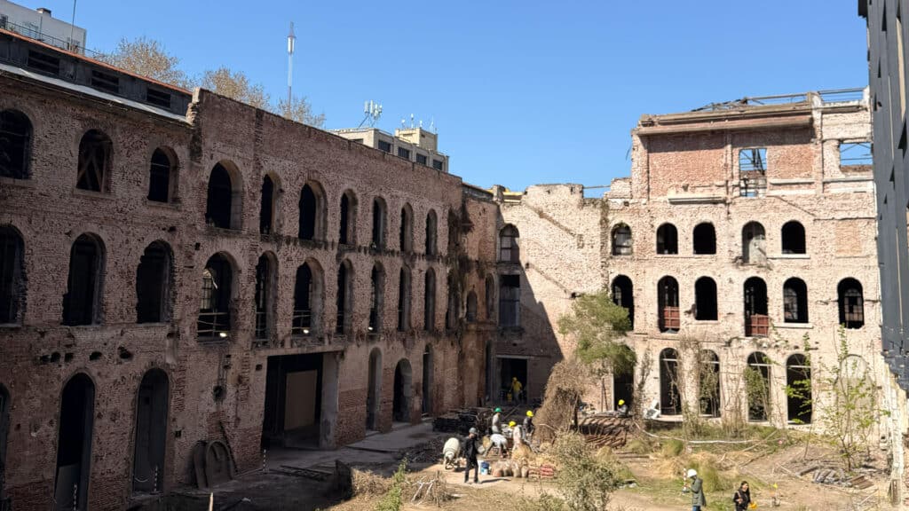 Patio del Palacio Molina con fachadas históricas de ladrillo y trabajadores durante la obra